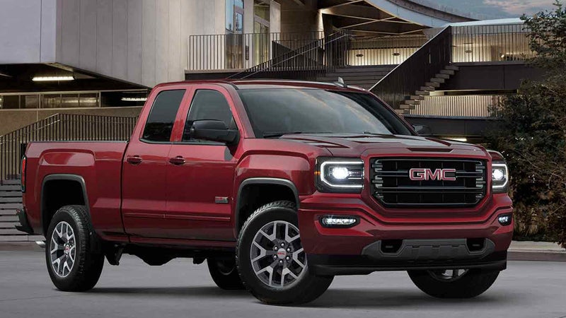 Red GMC Sierra 1500 standing on road