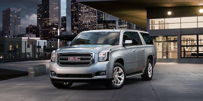 grey GMC Yukon standing near building