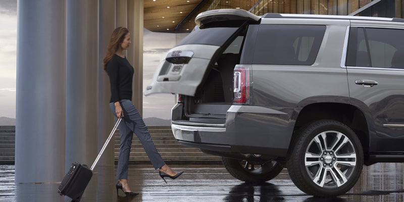woman opening boot space of GMC Yukon