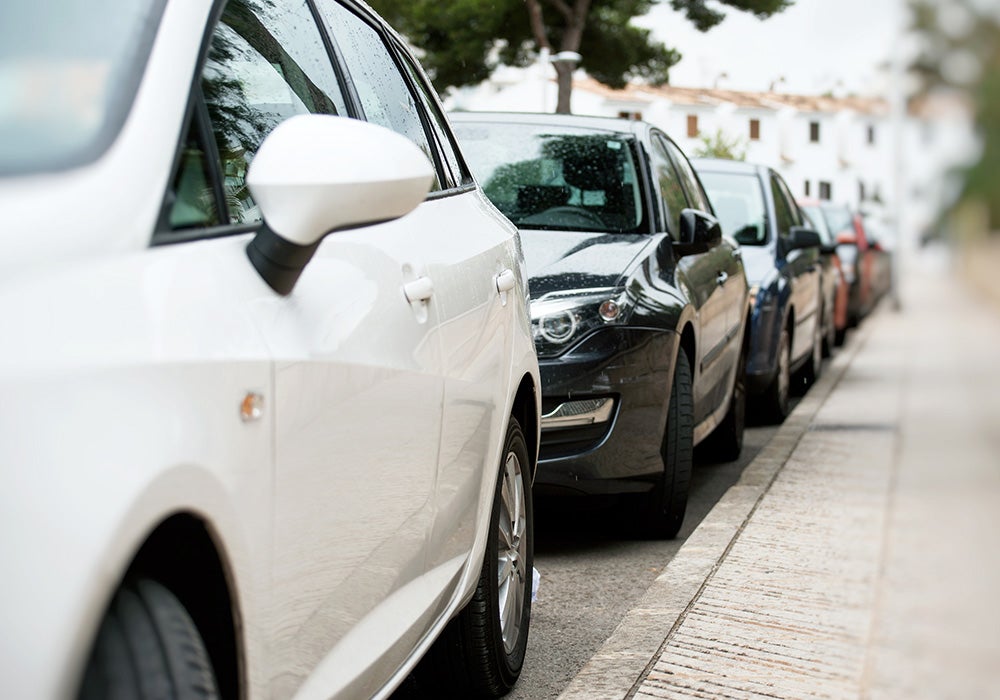 Cars parked in a row along the sidewalk